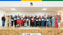 Imagem com vários alunos com os certificados, posando para foto em pé.